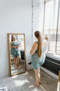A woman looking at her reflection in the mirror.