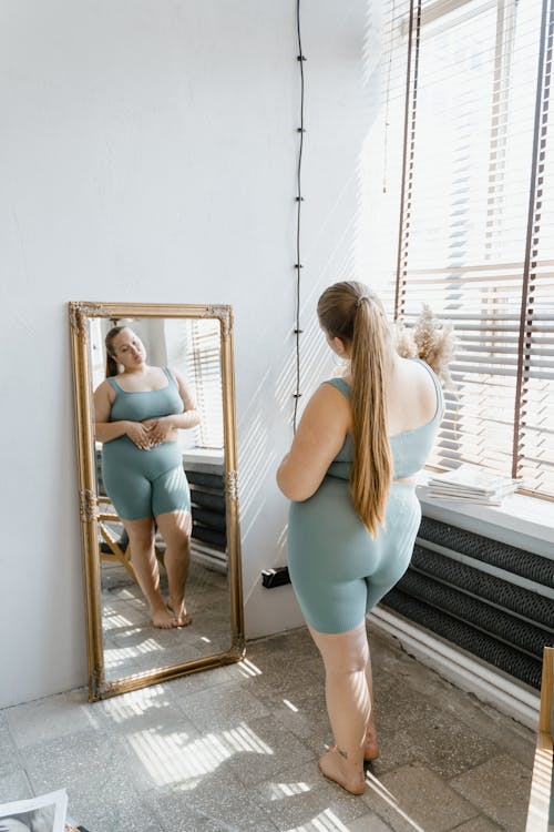 A woman looking at her reflection in the mirror.