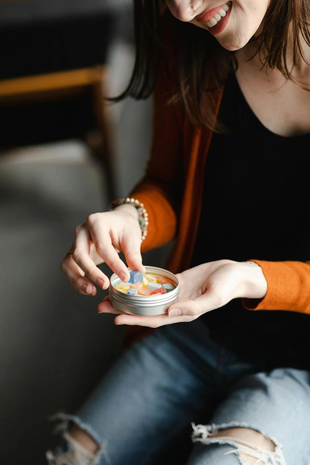 A woman holding and consuming fat-burning gummies, representing a new trend in weight loss supplements.