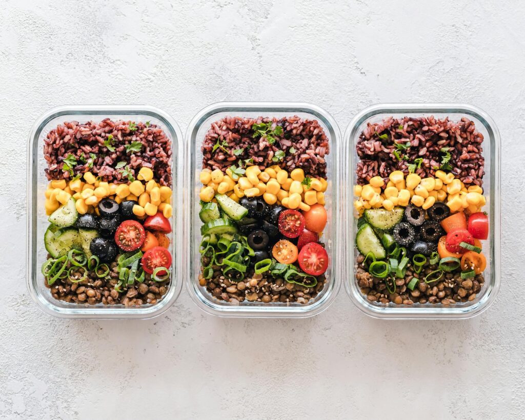 Three containers filled with different healthy weight loss meals, showcasing pre-portioned food.