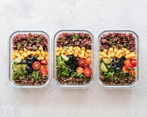 Three containers filled with different healthy weight loss meals, showcasing pre-portioned food.