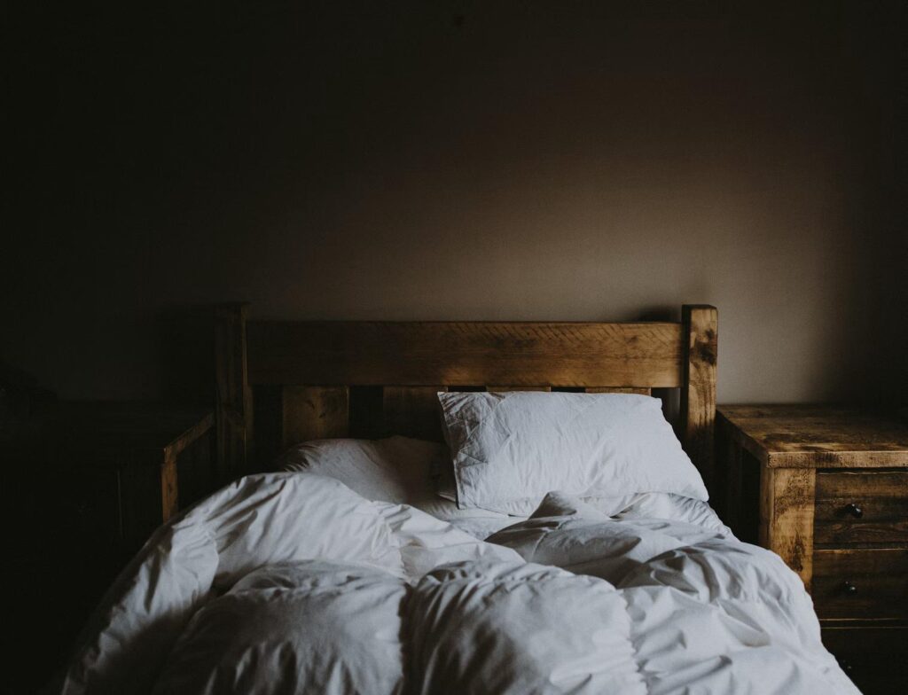 Unmade bed with natural morning light coming through the window