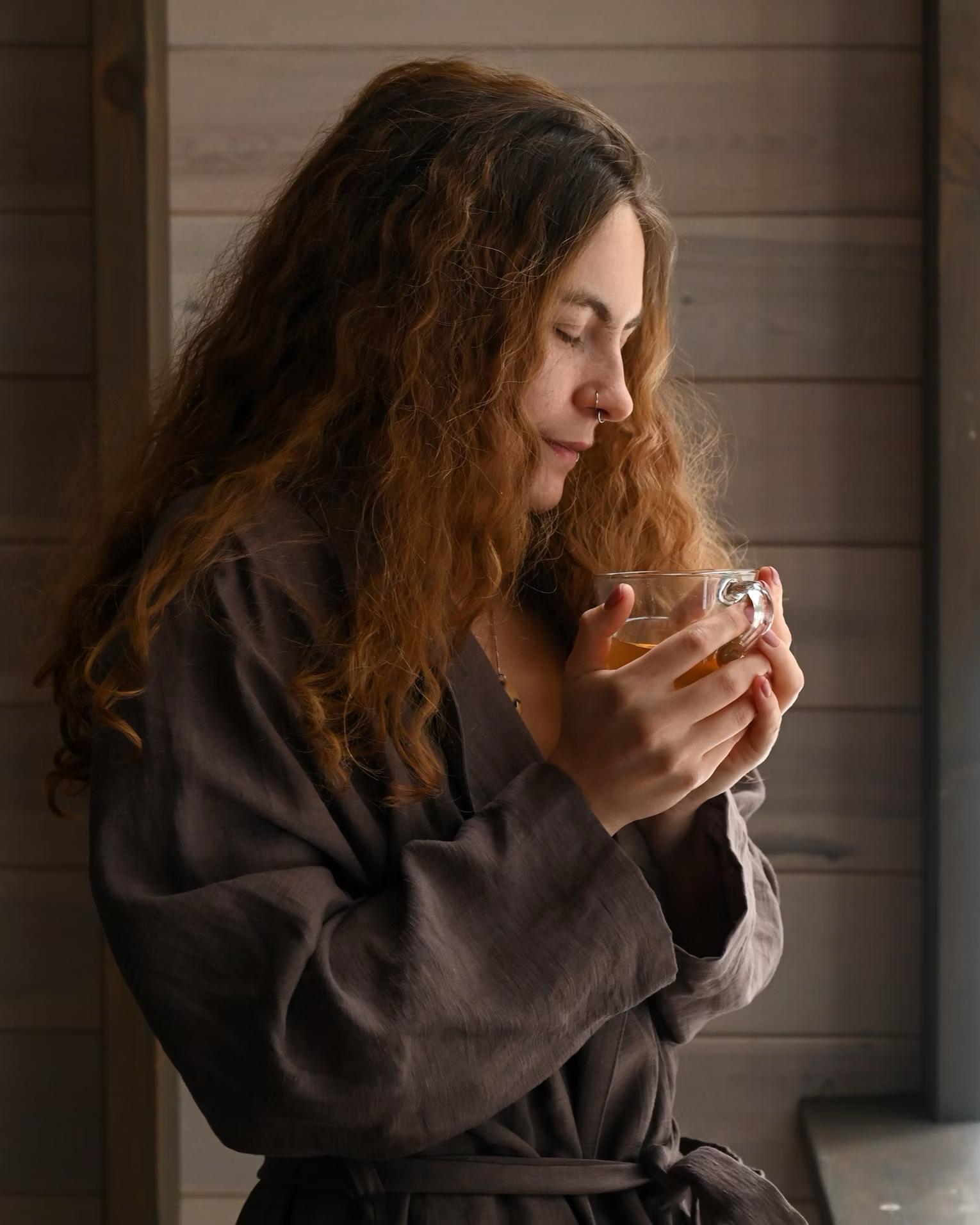 A woman about to drink a glass of the Okinawa Flat Belly Tonic.