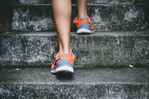 Close-up of person walking up stairs, representing daily fat-burning movement