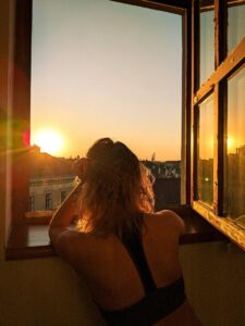 Woman sitting peacefully outdoors at sunset reflecting on wellness during menopause